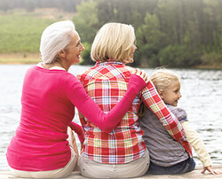 grandma, mother, and daughter sitting on a dock